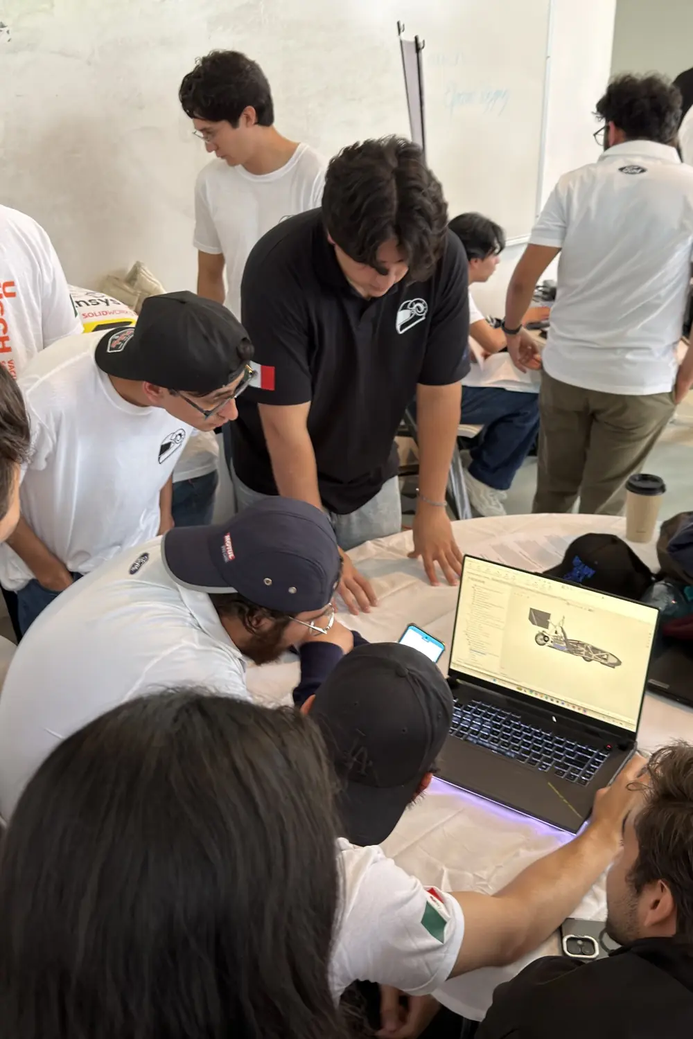 Members reviewing the CAD model of the car on a laptop between judging sessions